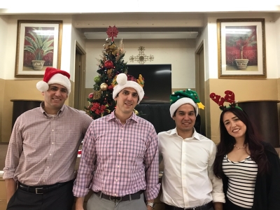 Members of Freidin Brown, P.A. wearing Christmas hats