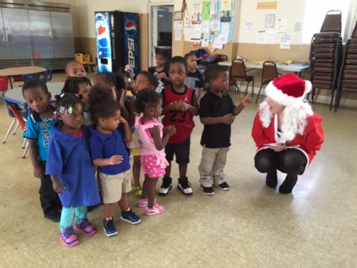 Woman dressed in Santa Claus in a room with kids