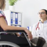 Disabled Woman in Wheelchair Sitting in Doctor's Office