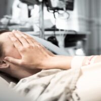 Young Woman Patient Lying at Hospital Bed Feeling Sad and Depressed