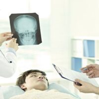 Man Lying in Hospital While the Doctor Examining His Brain X-Ray