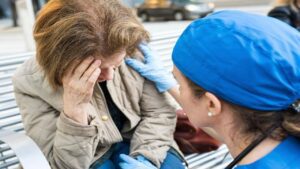 Female Doctor Assisting a Senior Woman Suffering from Headache