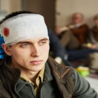 Nurse Bandaging the Head of Wounded Man