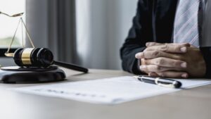 A Male Lawyer Sits in His Office, on a Table with a Small Hammer to Beat the Judge's Desk in Court